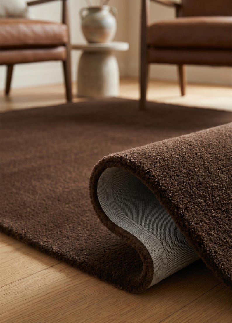 Macro shot highlighting the 13-16mm thick Premium New Zealand wool pile of this brown area rug, known across Europe as an elite luxury Tapis en laine.

Wide interior angle showing the perfect scale and rich solid brown palette, ideal for anchoring contemporary, minimalist, and boho decor.