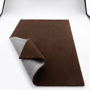 High-detail view showcasing the deep, uninterrupted mocha brown fibers, displaying exquisite handcrafted rugs artistry with a beautiful matte finish.