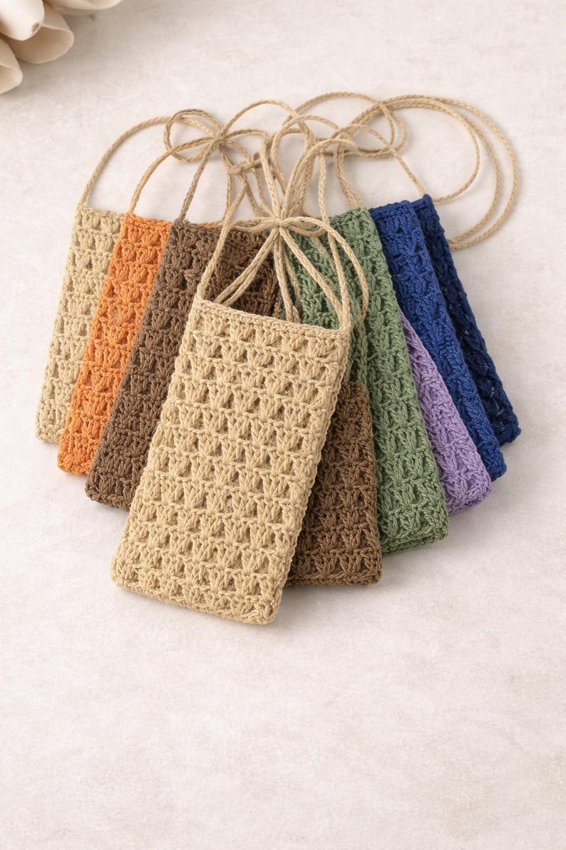 Pu&ograve; includere: Una collezione di sette custodie per telefono all'uncinetto in vari colori, tra cui beige, arancione, marrone, verde, blu e viola. Ogni custodia ha un cinturino intrecciato abbinato per il trasporto. Le custodie sono in materiale.