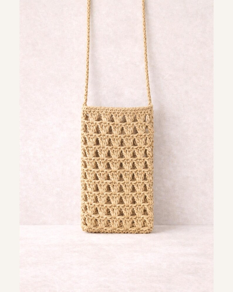 Pu&ograve; includere: Una borsa a tracolla beige intrecciata, di forma rettangolare, con una tracolla lunga e sottile. La borsa presenta un design a trama aperta a forma di reticolo e la tracolla sembra essere realizzata con lo stesso materiale.