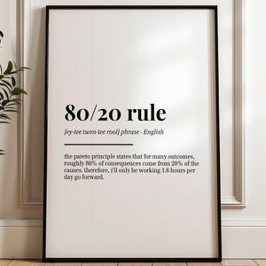 May include: A framed print featuring the text "80/20 rule" in black. The text explains the Pareto principle, stating that 80% of consequences come from 20% of causes. The print is in a black frame and set against a white background.