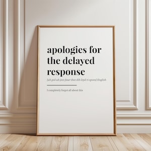 May include: A framed print with the text "apologies for the delayed response" in a black font. Below the main text is the phonetic pronunciation and the phrase "I completely forgot all about this". The frame is a light brown color.