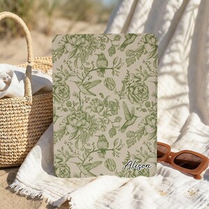May include: A rectangular tablet case featuring a beige background with a repeating green botanical pattern of hummingbirds and flowers. The name Alison is printed in a white script font in the bottom right corner of the case surface.