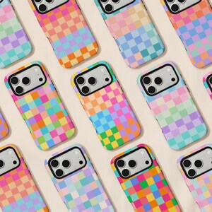 May include: A collection of smartphone cases featuring a repeating grid pattern of multicolored squares in shades of pink, orange, yellow, green, blue, and purple. Each case has a black camera cutout area with three circular lens openings.