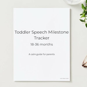 May include: A white book titled "Toddler Speech Milestone Tracker" with the subtitle "18-36 months" and the phrase "A calm guide for parents." The book is on a white surface with a plant and glasses.
