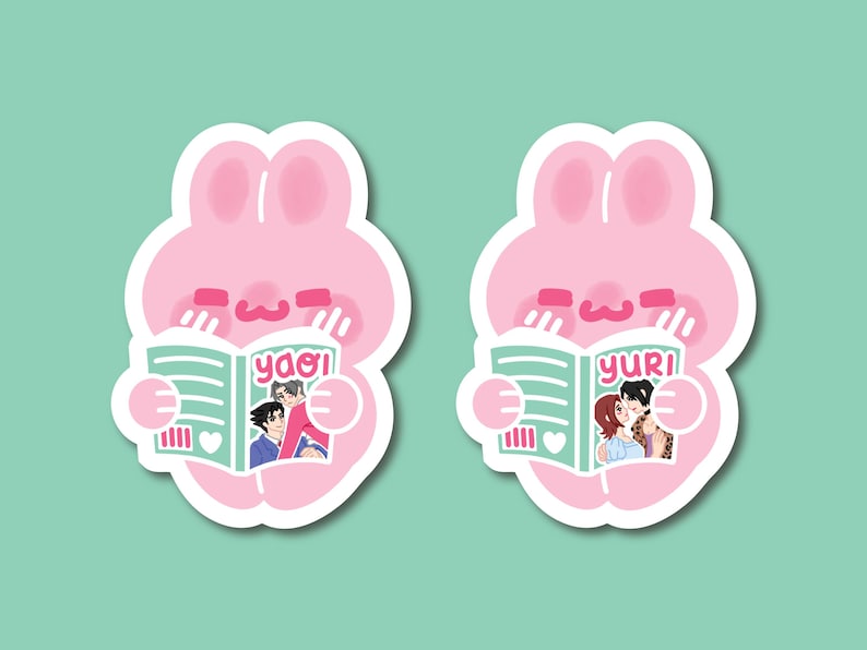 May include: Two die-cut stickers featuring a pink cartoon rabbit character with long ears. Each rabbit holds a light green book. The left sticker shows the text yaoi on the cover with an illustration of two people. The right sticker shows the text yuri.