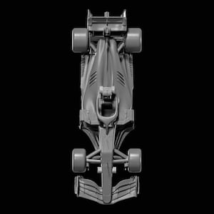 May include: Overhead view of a gray Formula 1 race car against a black background. The car has four large tires, a streamlined body, and a rear wing. The design includes aerodynamic features.