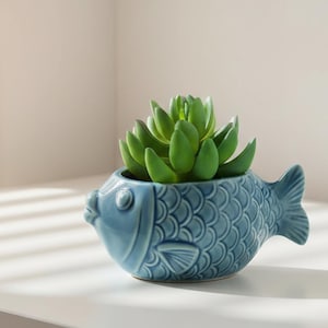 May include: A set of three ceramic mugs with a speckled, cream-colored glaze. Each mug features a different hand-painted floral design in shades of blue, green, and yellow. The mugs have a simple, rounded shape and a comfortable handle.