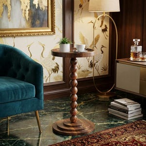 May include: A dark wood side table with a round top and a stacked ball design on the stem. The table has a small plant and a cup and saucer on top. The table is 61 cm tall.