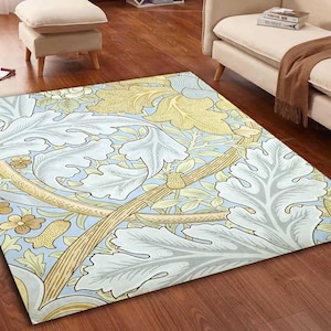 Puede incluir: Una alfombra rectangular con un patrón botánico repetitivo de grandes hojas de acanto estilizadas en gris claro, follaje amarillo dorado y pequeñas flores sobre un fondo azul pálido con tallos finos y curvos de color marrón.