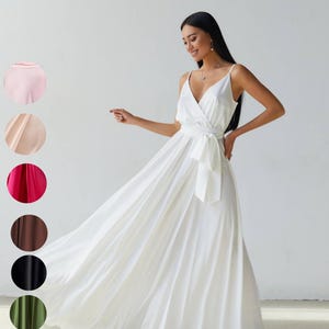 May include: A white satin maxi dress with a V-neckline and spaghetti straps. The dress features a wrap-around waist with a bow. Color swatches of pink, beige, red, brown, black, green, and white are shown on the left.