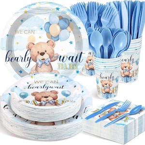 May include: A party supply set featuring light blue and tan teddy bears with the text "WE CAN bearly wait BABY". The set includes stacks of round paper plates, light blue plastic forks, spoons, and knives, paper cups, and a stack of paper napkins.