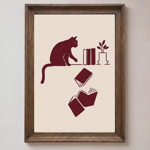 Katze wirft Bücher vom Regal – Lustiges Katzenbild für die Wand, Geschenkidee für Bücherliebhaber