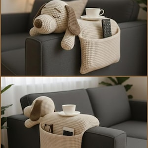 Könnte beinhalten: Ein beigefarbener Sofa-Armlehnen-Organizer aus Häkelarbeit mit einem Stoffhundekopf mit braunen Ohren und Nase. Er verfügt über eine flache Oberfläche für eine Tasse mit Untertasse und eine Seitentasche mit Fernbedienung, Brille und Smartphone.