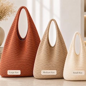 Peut inclure: Trois sacs en crochet de tailles et de couleurs différentes. Le plus grand sac est orange rouille, le sac moyen est beige et le plus petit est crème. Chaque sac possède une anse intégrée et une étiquette indiquant Large Size, Medium Size ou Small Size.