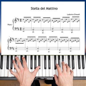 Può includere: Una tastiera di pianoforte con tasti bianchi e neri, con spartito intitolato "Stella del Mattino" di Ludovico Einaudi. Lo spartito è per pianoforte e le mani suonano il pianoforte.