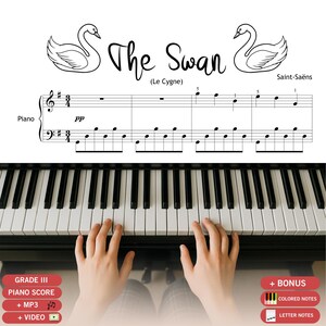 Könnte beinhalten: Ein Klaviernotenblatt mit dem Titel The Swan (Le Cygne) von Saint-Saëns, mit zwei Schwanenillustrationen, Notenschrift im 3/4-Takt und einer Klaviertastatur darunter. Der Text umfasst Grade III, Piano Score, + MP3, + Video und + Bonus.