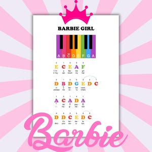 Op de afbeelding: Een witte print met de woorden "Barbie Girl" en een regenboog pianoklavierafbeelding. De print bevat muzieknoten en songteksten, met een roze kroon bovenaan en de naam "Barbie" in cursiefschrift onderaan.