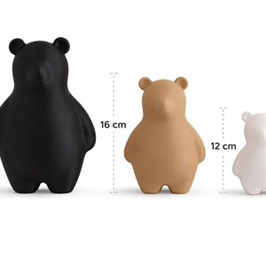 Pu&ograve; includere: Tre statuette di orsi in nero, beige e bianco. L'orso nero &egrave; alto 20 cm, l'orso beige 16 cm e l'orso bianco 12 cm. Gli orsi hanno un design minimalista con corpi arrotondati e piccole orecchie.