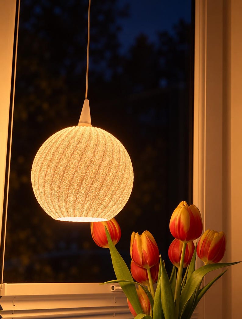 NOVA Lampenschirm mit warmer Beleuchtung am Fenster.