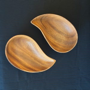 Puede incluir: Un juego de tres tazas de cerámica con un acabado mate moteado. Las tazas son de color crema, marrón claro y marrón oscuro. Cada taza tiene un diseño simple y minimalista.