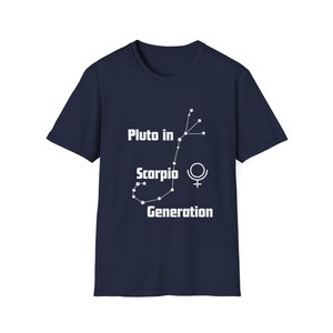May include: Navy blue t-shirt with white text and a constellation graphic. The text reads "Pluto in Scorpio Generation" with a Scorpio constellation design and a Venus symbol.