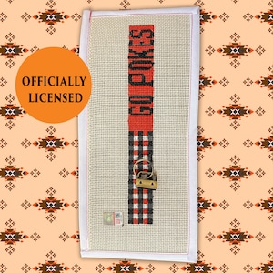 May include: A white ceramic mug with a black handle and the text "But First, Coffee" in a bold, black font. The mug is set against a blurred background, suggesting a cozy setting. The mug appears to be approximately 4 inches tall.