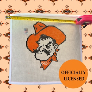 May include: A white ceramic mug with a black handle and the text "But first, coffee" in a black, handwritten-style font. The mug is on a white surface.