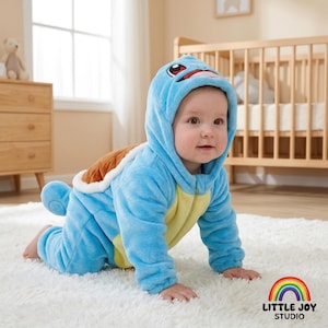 May include: A light blue plush baby onesie featuring a hood with a character face, a yellow belly panel, and a brown turtle shell on the back. The long-sleeved garment has a zipper closure and a small tail, designed to resemble a turtle creature.