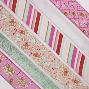 May include: Five decorative ribbons arranged diagonally. Patterns include gingerbread men, Christmas trees, and snowflakes on a tan background, diagonal stripes in red, pink, and mint green, a solid silver glitter, and pink with gingerbread houses.