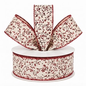 May include: A spool of cream-colored ribbon featuring a repeating pattern of dark brown branches with small, glittery red berries. The edges of the ribbon are finished with a thin, sparkling red trim, and the ribbon is looped into a bow shape.