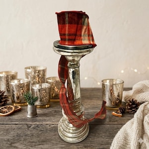 May include: A white ceramic mug with a black handle and the text "But First, Coffee" in a black, bold font. The mug is on a white surface.