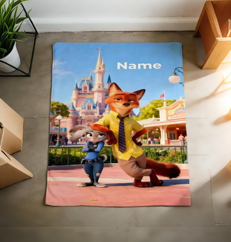 May include: A rectangular blanket featuring the characters Nick Wilde and Judy Hopps from Zootopia, with a castle backdrop and the word "Name" in white. The blanket has a pink border and a blue sky background.
