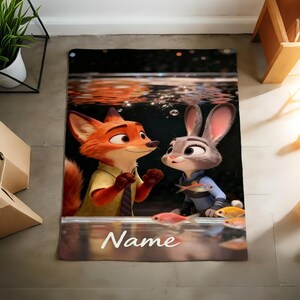 May include: A rectangular Zootopia-themed rug featuring Nick Wilde and Judy Hopps underwater with fish. The rug has a black background with the word "Name" in white at the bottom. The characters are in vibrant colours.