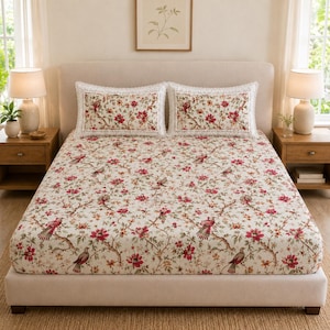 May include: A bed set featuring a cream-coloured fitted sheet and two matching rectangular pillowcases, all decorated with a repeating pattern of red flowers, green leaves, and small brown birds perched on thin, dark brown branches.