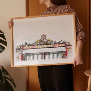 May include: A framed watercolor painting of the Anfield stadium gate with the words "You'll Never Walk Alone" in gold lettering.