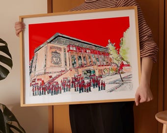 May include: A framed watercolor painting of a stadium with a red background. The stadium is drawn in detail with a crowd of people in front of it. The painting is in a wooden frame.