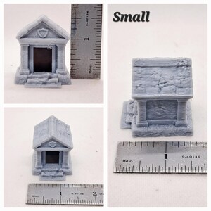 May include: Three gray miniature crypts are displayed, each with a detailed architectural design. The crypts have a rectangular shape with a pitched roof and a small door. The word "Small" is written in black text. Measurements are shown in inches.