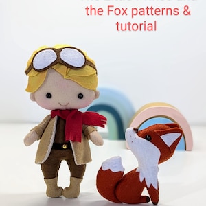 May include: Felt toy patterns for The Little Prince and the Fox. The patterns include a boy with blonde hair wearing a brown jacket, red scarf, and goggles, and a fox with orange fur and a white tail.
