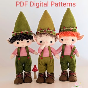 Op de afbeelding: Drie vilten elfpoppen met groene hoeden, rood-wit gestreepte shirts, groene broeken en bruine schoenen. De elfen hebben verschillende haarkleuren: bruin, blond en rood. De poppen staan op een wit oppervlak. PDF-digitale patronen.