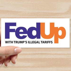 May include: A white rectangular sticker with the words "Fed Up" in blue and orange, mimicking a well-known logo. Below, the text reads "WITH TRUMP'S ILLEGAL TARIFFS" in black. The sticker is held by a hand.