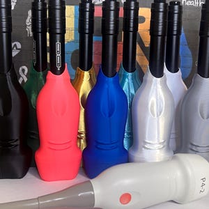 May include: A collection of ultrasound probe covers in various colors including black, red, blue, silver, yellow, green, and white. Each cover features a long black handle and a contoured base. A single white ultrasound probe labeled P4-2 lies horizontally in the foreground.