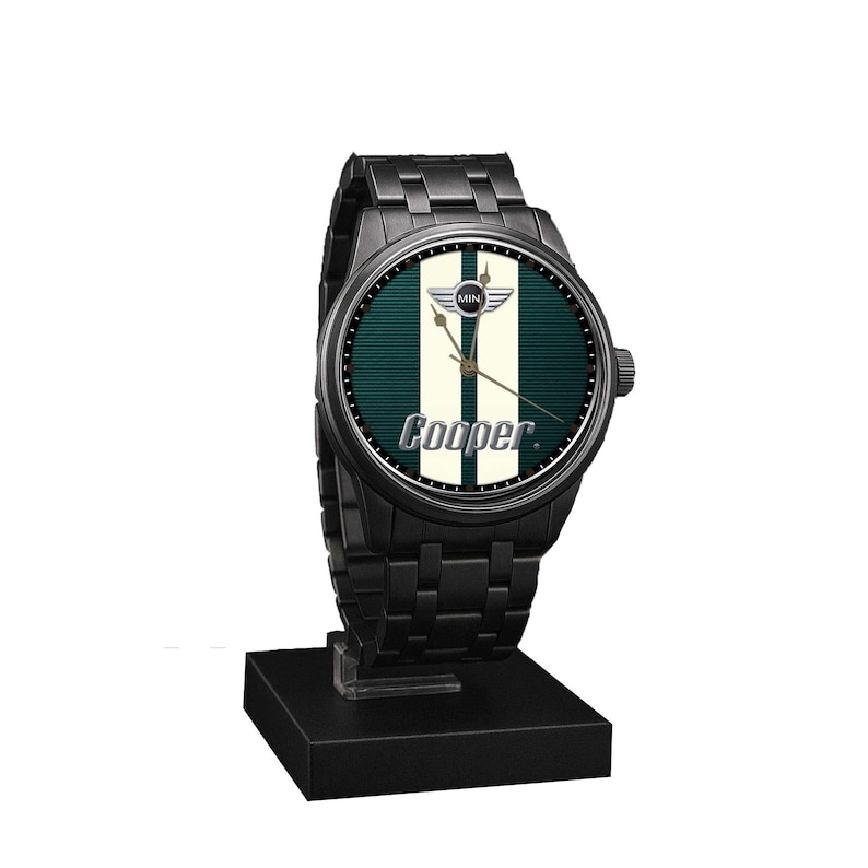 May include: Black wristwatch with a round face featuring a green and white striped design and the word "Cooper." The watch has a black metal band and is displayed on a black stand. The watch face includes the Mini logo.