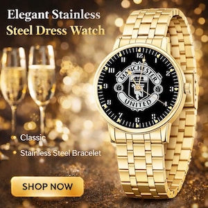 May include: A gold-toned stainless steel dress watch with a black face featuring the Manchester United logo. The watch has a matching gold bracelet and is displayed with champagne flutes. The text reads "Elegant Stainless Steel Dress Watch."