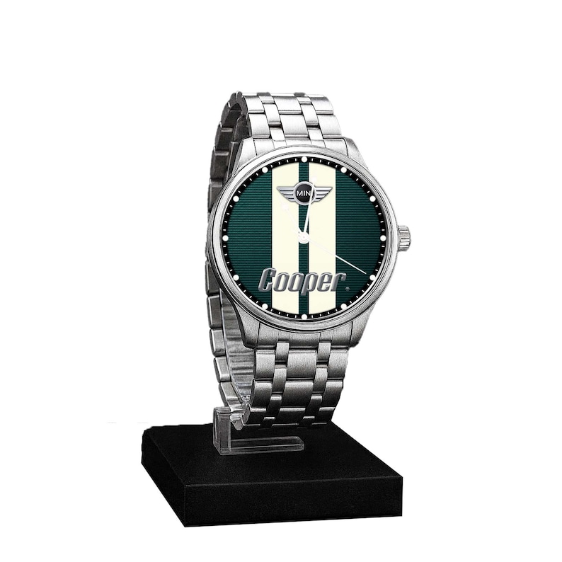 May include: A silver wristwatch with a green and white face, featuring the word "Cooper" and the Mini logo. The watch has a stainless steel band and is displayed on a black stand.