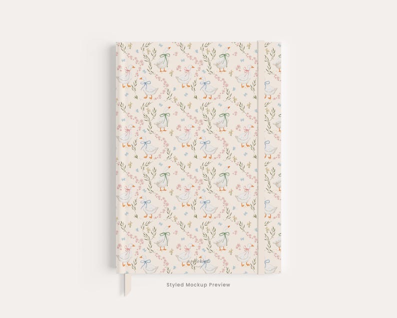 May include: A hardcover notebook with a cream-colored background featuring a repeating pattern of white geese wearing blue, green, or pink bows, interspersed with small green leafy sprigs and tiny pink flowers. The spine is a solid cream color.
