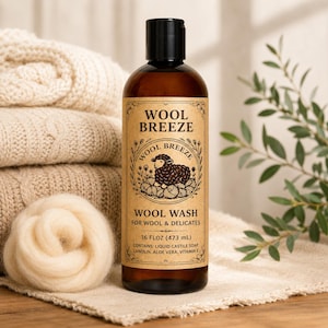 May include: A brown plastic bottle of Wool Breeze wool wash with a black cap. The label features a black sheep illustration, the text Wool Breeze, Wool Wash for Wool & Delicates, and 16 fl oz (473 mL) with ingredients listed below.