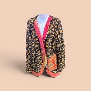 May include: A black jacket with a floral pattern in gold and yellow. The jacket has a pink and red patterned lining. The jacket is displayed on a white mannequin.