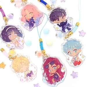 Peut inclure: Une collection de breloques en acrylique de style anime colorées avec des attaches dorées et des lanières attachées. Les breloques présentent divers personnages avec différentes couleurs de cheveux et tenues, entourés d'ornements en forme d'étoiles et sphériques.