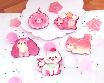 May include: Five pink and white painted wooden animal figurines. The figurines are of a unicorn, a dog, a cat, a Shiba Inu, and a dog with a flower in its hair. The figurines are on a white background with pink and white confetti.